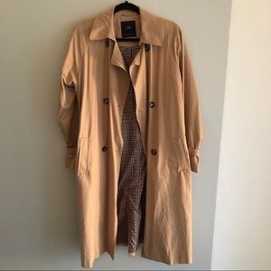 Beige trench coat with a belt and checked lining